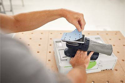 Artesão coloca lixa na lixadora