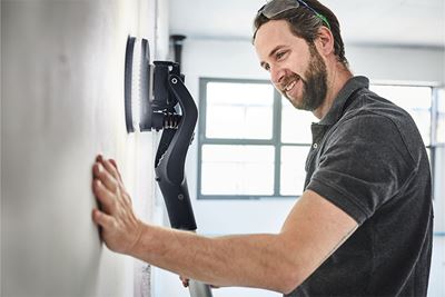 Artesão trabalha parede com uma lixadora de braço extensível Planex com iluminação