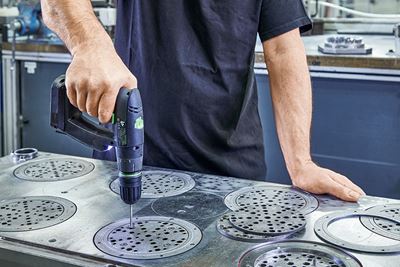 Artesão trabalha placas de lixa de metal