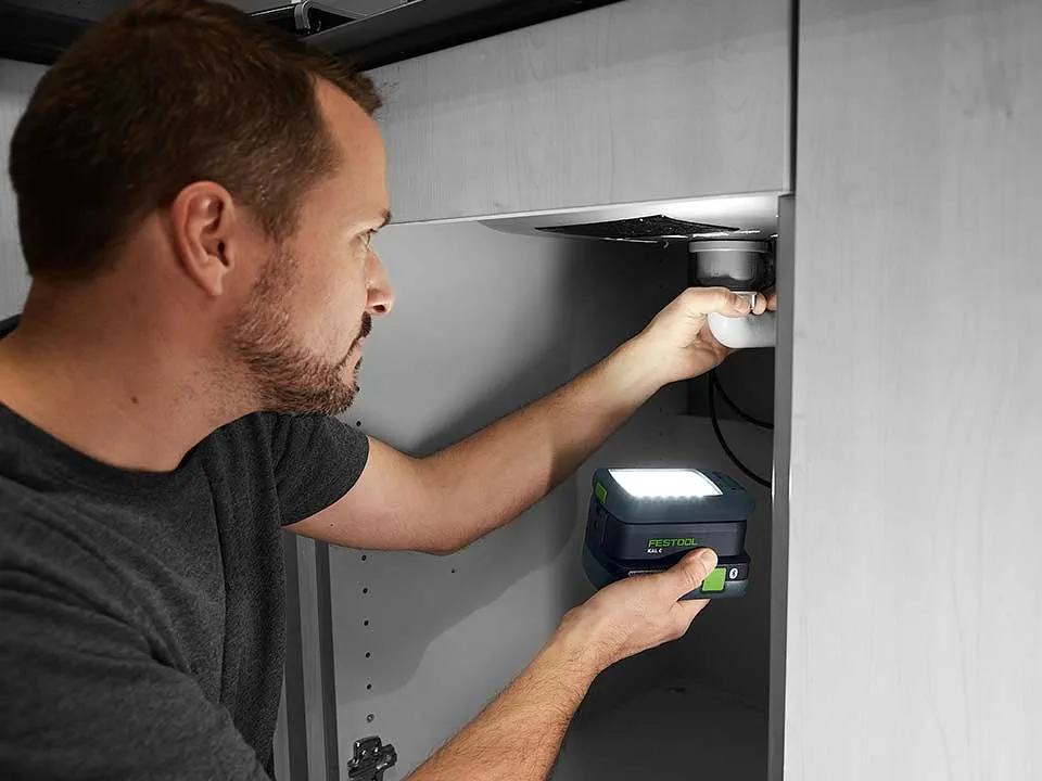 Um homem ilumina a ligação de um lavatório com o SYSLITE KAL 2